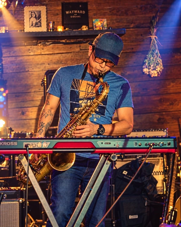 Chris playing tenor saxophone and keys on stage in New York